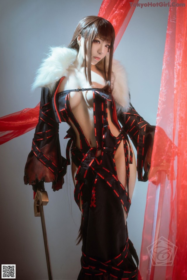 A woman in a black and red outfit holding a sword.