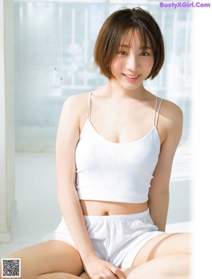 A woman sitting on top of a white bench.