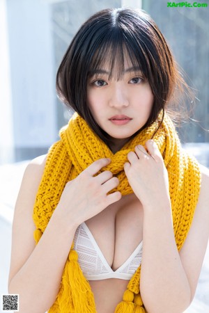 A woman in a white bikini and a yellow scarf.