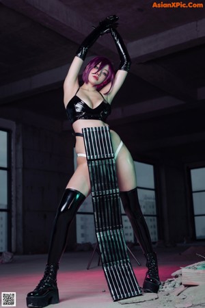 A woman in a black latex outfit is posing for a picture.