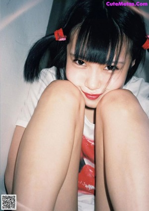A woman sitting on top of a wooden chair.