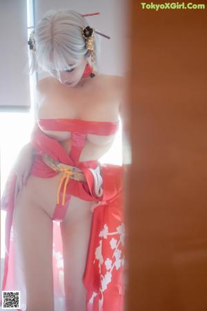 A woman in a red kimono sitting on a window sill.