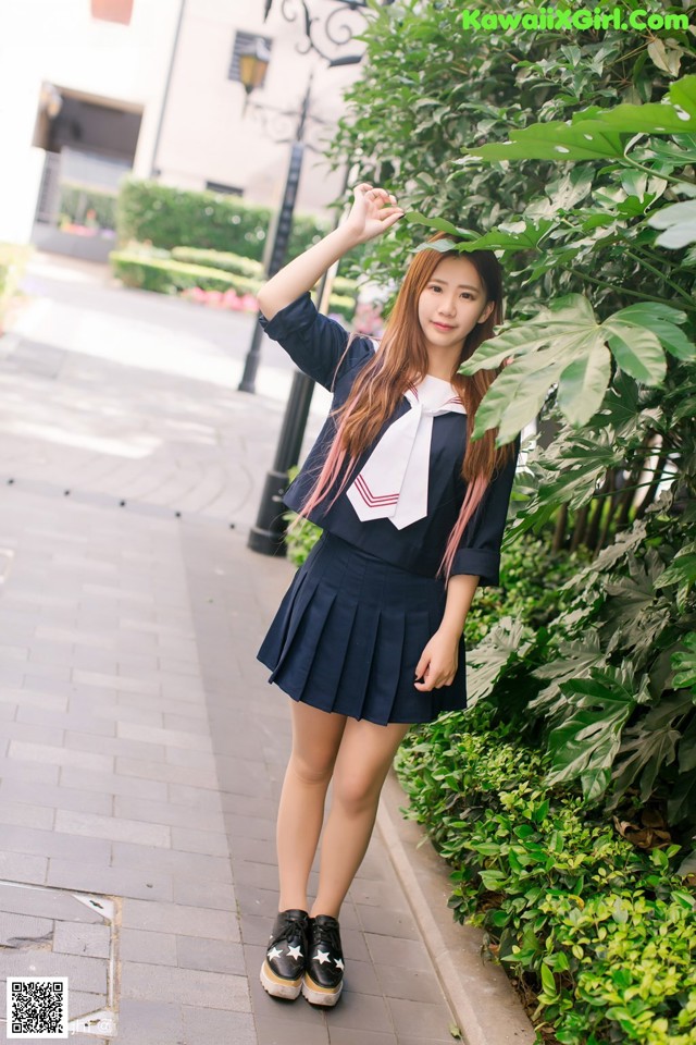 A woman in a school uniform posing for a picture.