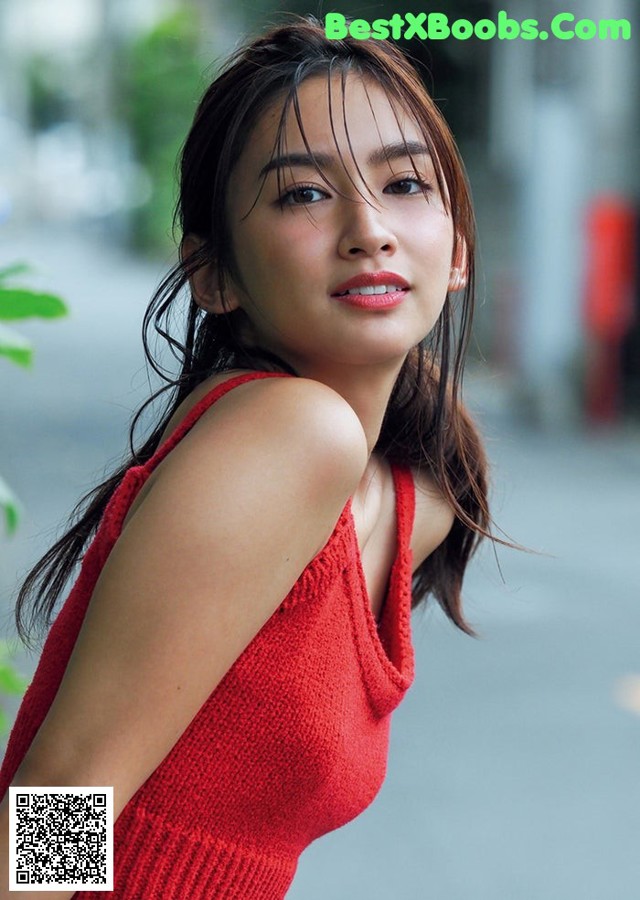 A woman in a red dress posing for a picture.