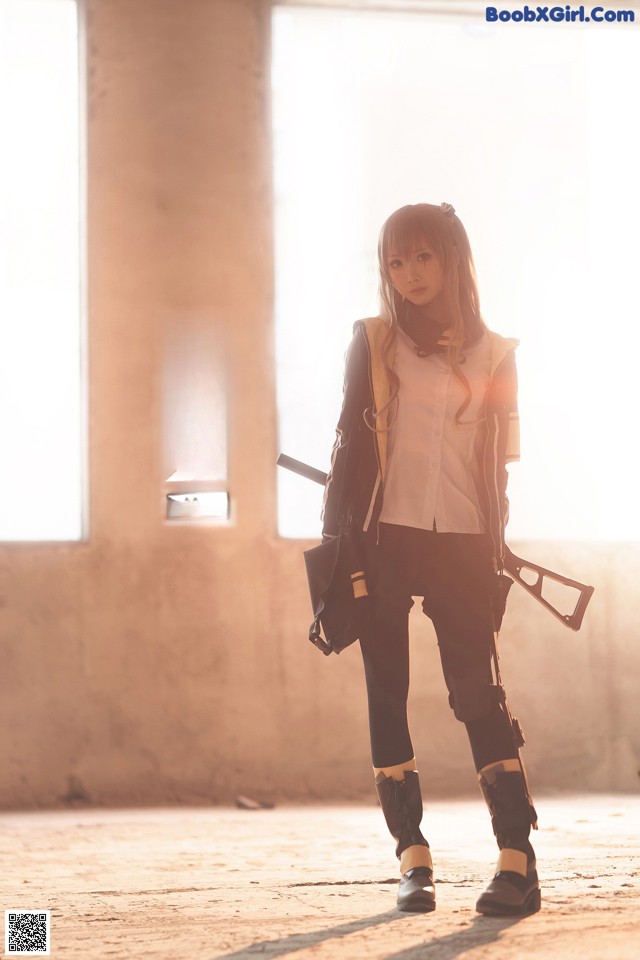 A woman in a white shirt and black pants holding a gun.