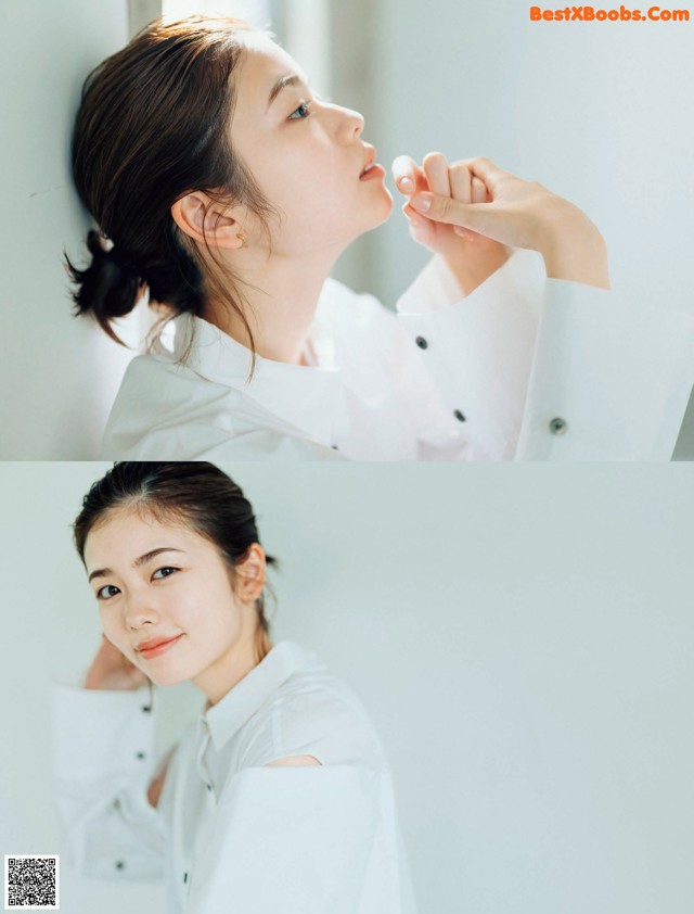 A woman in a white shirt is looking up at the sky.