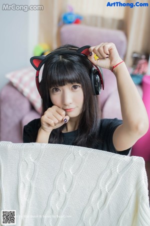 A woman sitting on a bed holding a stuffed animal.