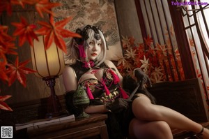 A woman in a black and pink outfit sitting on a table.