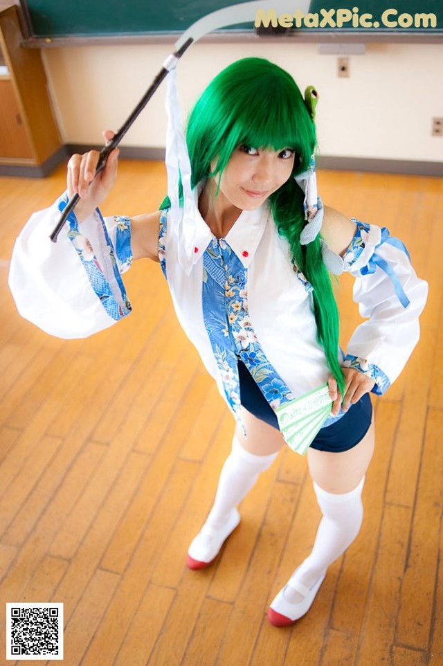 A woman with green hair holding a scythe in a classroom.