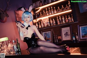 A woman in bunny ears sitting at a bar.