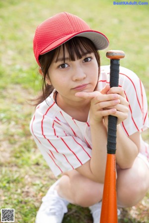 A woman in a baseball uniform holding a baseball glove.