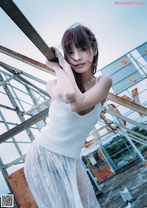 A woman standing on top of a roof under a cloudy sky.