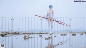 A woman with blue hair sitting on a metal structure.