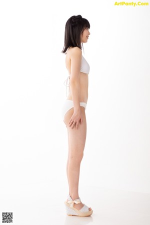 A woman in a white bikini posing for a picture.