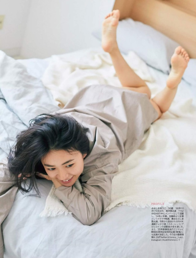 A woman laying on a bed with her feet up.