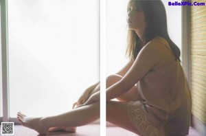 A woman laying on the floor next to a window.