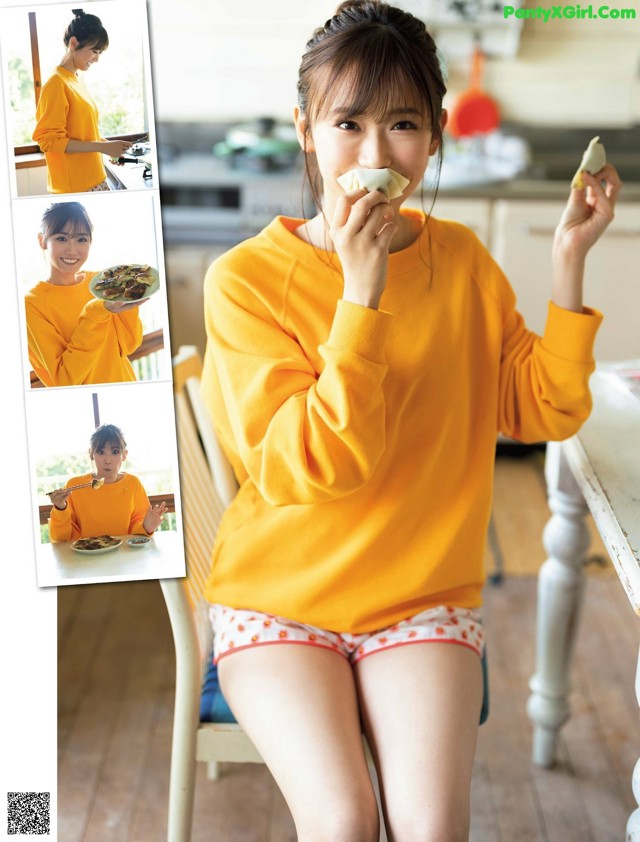 A woman sitting at a table eating a piece of food.