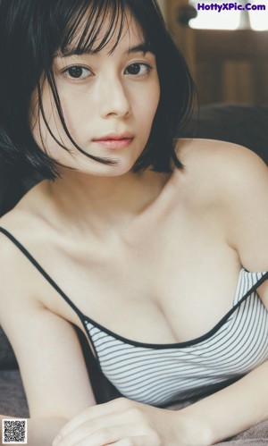 A woman with short black hair is looking at the camera.