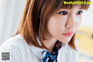 A woman in a school uniform posing for a picture.