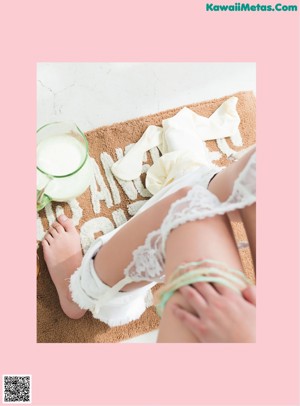 A woman in a white bathing suit sitting on the ground.