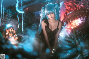 A woman with long blue hair wearing a black dress.