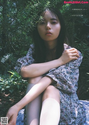 A woman laying on top of a bed next to a green wall.