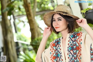 A woman in a straw hat posing for the camera.