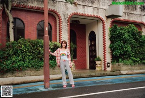 A woman standing in front of a green building.