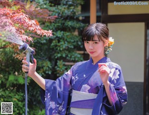 A woman in a red and white kimono is looking at the camera.