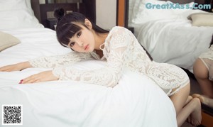 A woman sitting on a bathtub in front of a mirror.