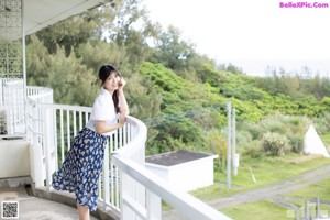 A naked woman standing in front of a window.