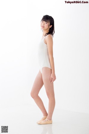 A woman in a white bodysuit posing for a picture.