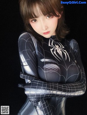 A woman in a black and silver spider suit taking a selfie.