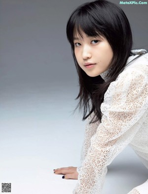 A woman laying on top of a white table.