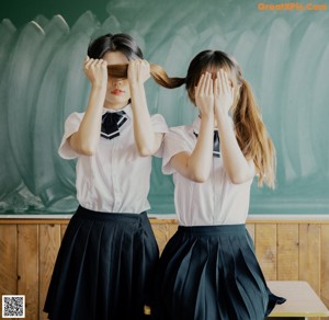 A group of young women in school uniforms posing for a picture.