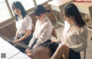 A group of young women in school uniforms are tied up.