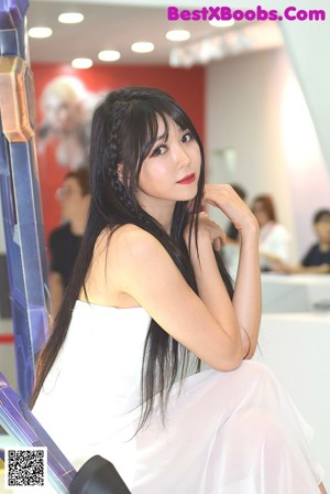 A woman in a white and black outfit posing for a picture.