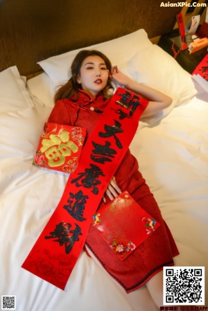 A woman in a pink bikini holding a red envelope.